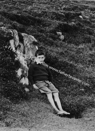 BOY RESTING ON GRASS